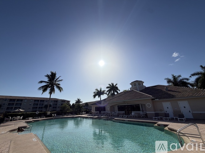 A sunny day at the pool with a building in the background.
