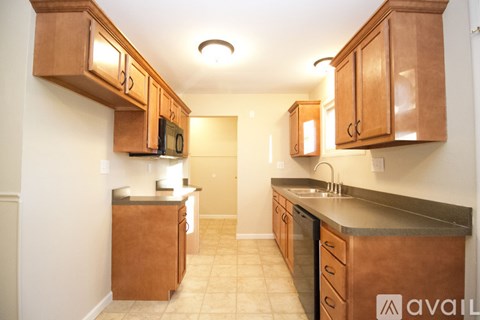 A kitchen with wooden cabinets and a black countertop.