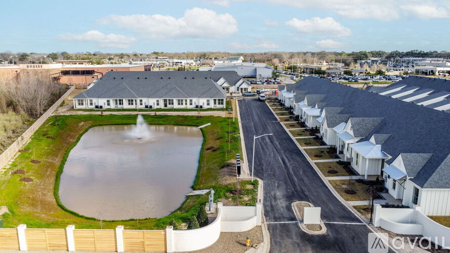 A large building complex with a fountain in the middle of a grassy area.