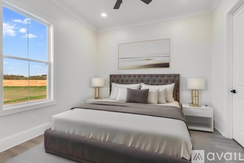 A bedroom with a large bed and a ceiling fan.