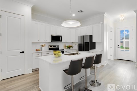 A modern kitchen with white cabinets and a central island.