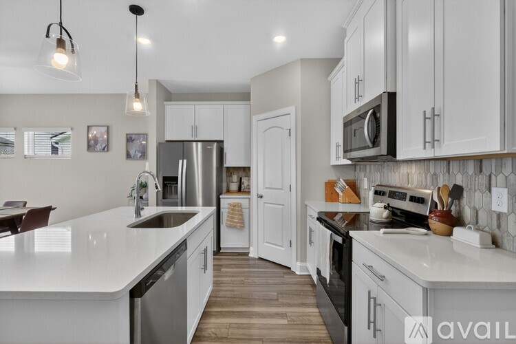A modern kitchen with white cabinets and a white countertop.