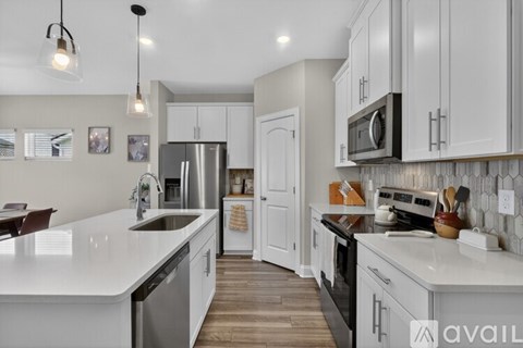 A modern kitchen with white cabinets and a white countertop.