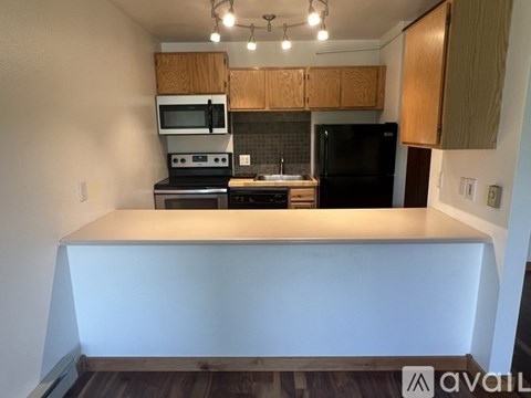 A kitchen with wooden cabinets and black appliances.