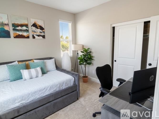 A bedroom with a bed, desk, and chair.