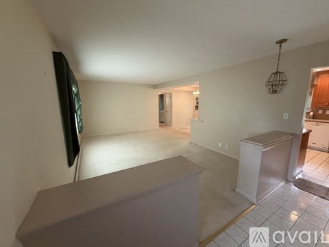 A living room with a grey couch and a television on the wall.