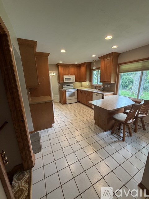 A kitchen with a tile floor and wooden cabinets.