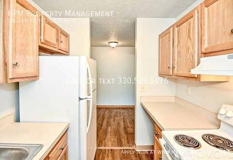 A kitchen with a white refrigerator and wooden cabinets.