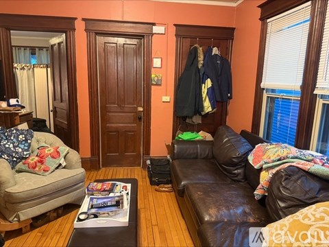 A living room with a brown leather couch and a coffee table with a magazine on it.