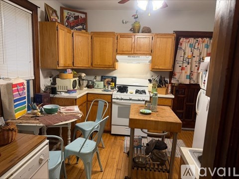 A kitchen with a white stove top oven and a white refrigerator.