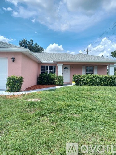 A pink house with a white door and windows.