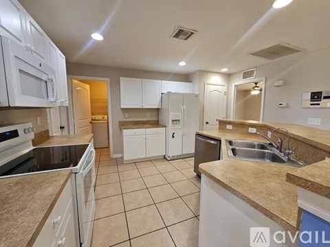 A kitchen with white cabinets and a granite countertop.