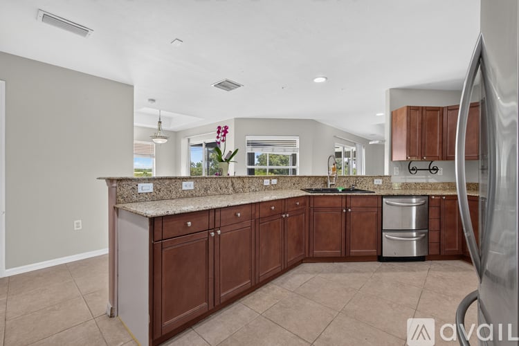 A kitchen with brown cabinets and a granite countertop.
