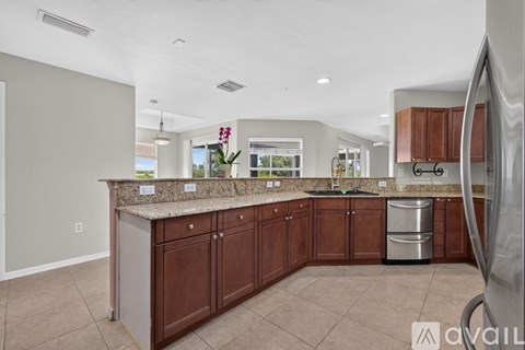 A kitchen with brown cabinets and a granite countertop.
