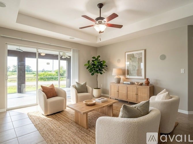 A living room with a ceiling fan, two chairs, a sofa, a coffee table, and a potted plant.
