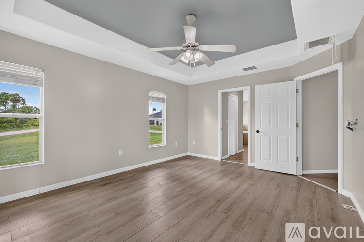 A spacious room with a ceiling fan and wooden flooring.
