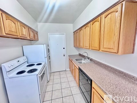 A kitchen with a white stove and wooden cabinets.