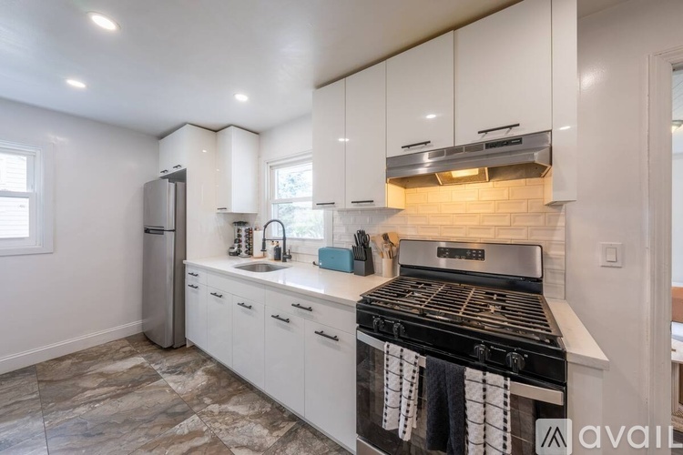 A kitchen with white cabinets and a black stove top.