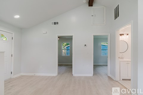 A spacious room with a doorway leading to another room.