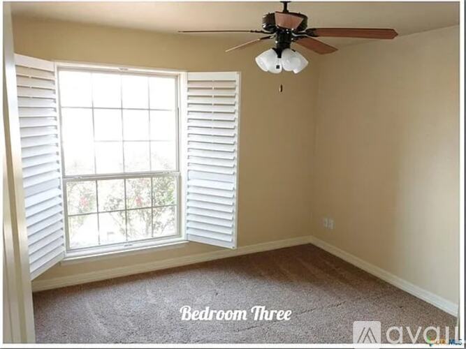 Bedroom three has a window with shutters and a ceiling fan.