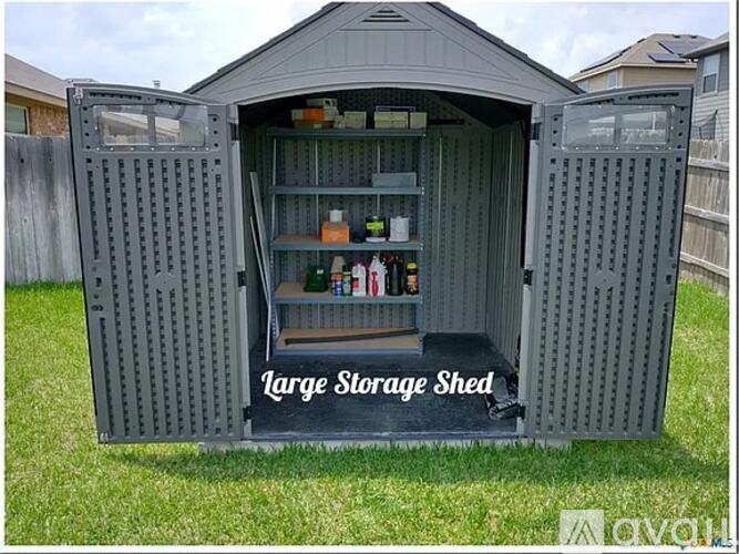 A large storage shed with the door open, revealing shelves and storage space.