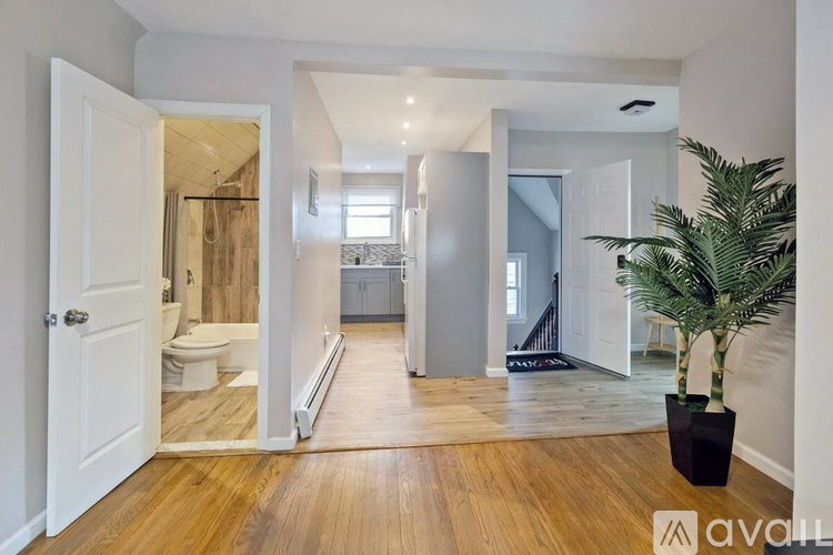 A spacious hallway with a toilet visible through the open door.