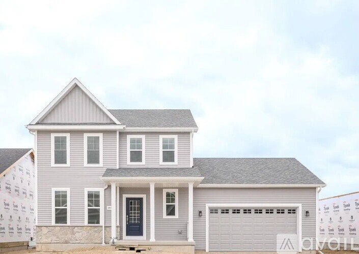 A two-story house with a grey exterior and a black front door.