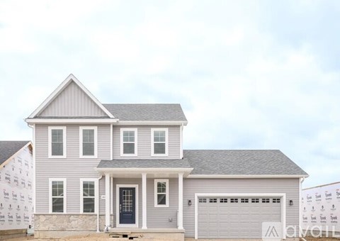 A two-story house with a grey exterior and a black front door.