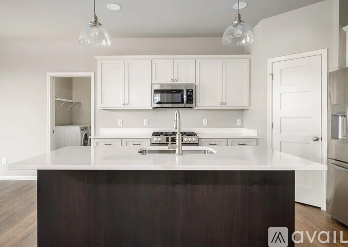 A kitchen with white cabinets and a dark counter.