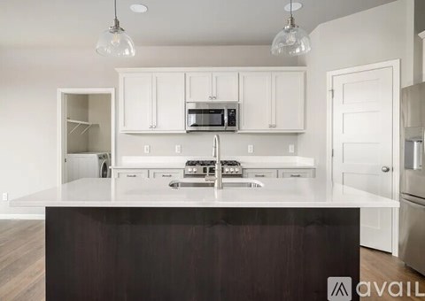 A kitchen with white cabinets and a dark counter.