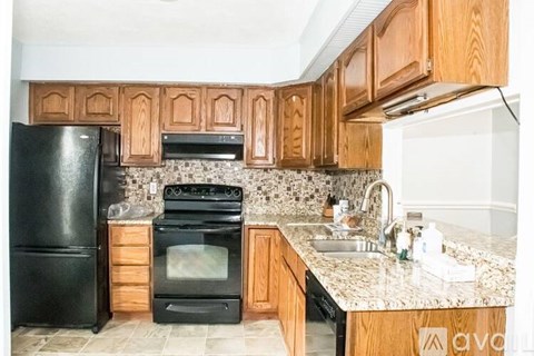 A kitchen with black appliances and wooden cabinets.