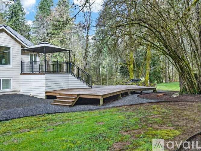 A house with a deck and a patio surrounded by trees.