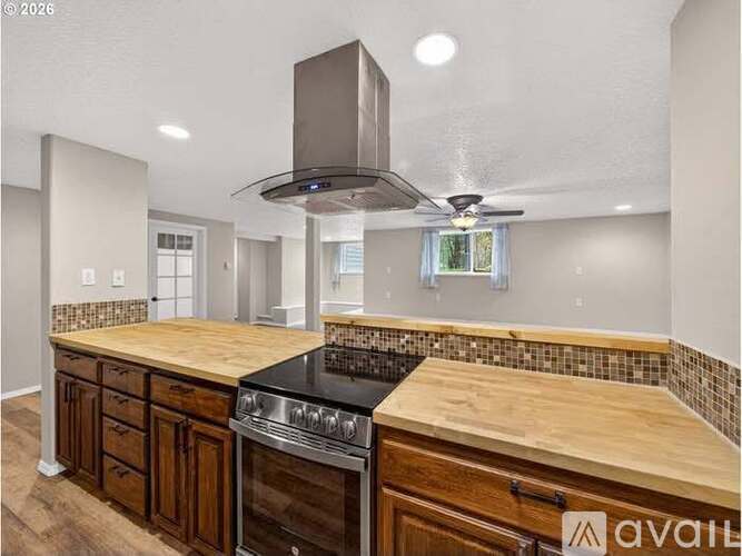 A kitchen with wooden cabinets and a black stove top oven.