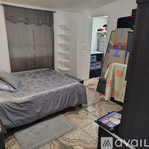 A bedroom with a bed, a dresser, and a wardrobe.