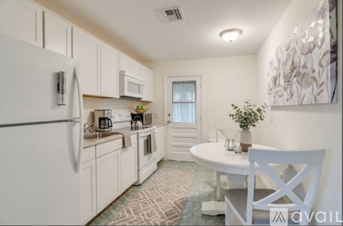 A kitchen with white cabinets and a white fridge.