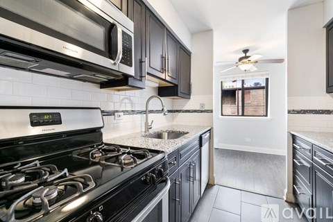 A modern kitchen with a stove, microwave, and oven.