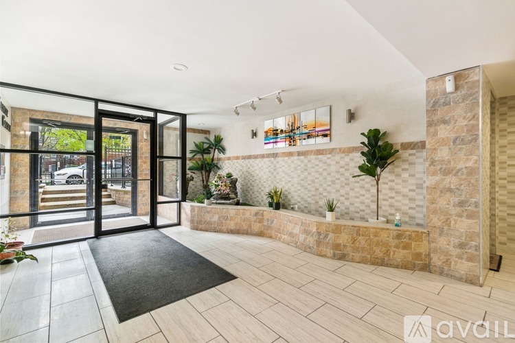 A modern house entrance with a glass door and a black mat.