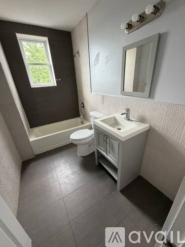 A bathroom with a toilet, sink, and bathtub.