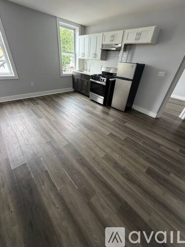 A kitchen with a wood floor and white cabinets.