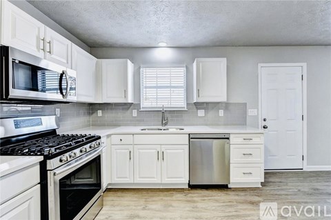 A kitchen with white cabinets and a black stove top oven.