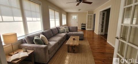 A living room with a grey couch and a wooden coffee table.