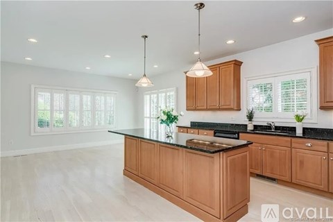 A kitchen with wooden cabinets and a black countertop.