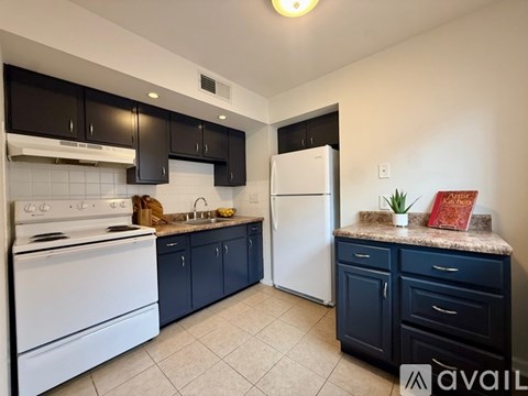 A kitchen with black cabinets and white appliances.