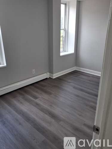 A room with grey flooring and a window.