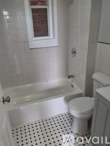 A white toilet sits next to a bathtub in a bathroom.