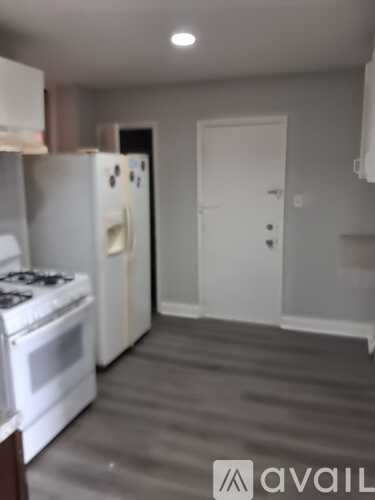 A kitchen with a white stove and refrigerator.