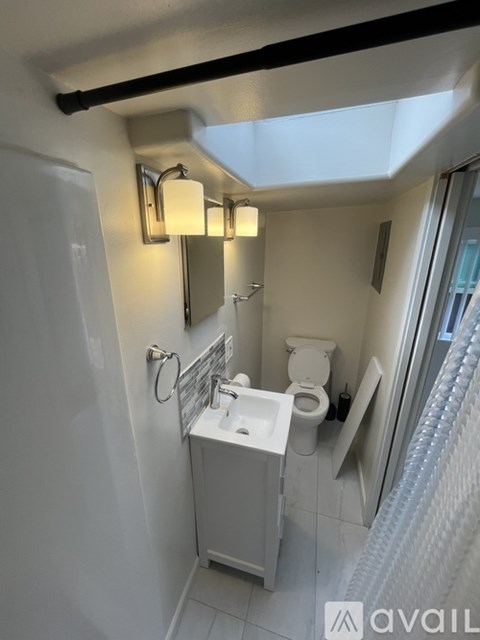 A bathroom with a toilet, sink, and mirror.