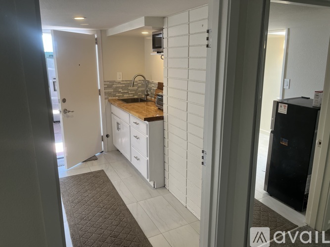 A kitchen with white cabinets and a wooden countertop.