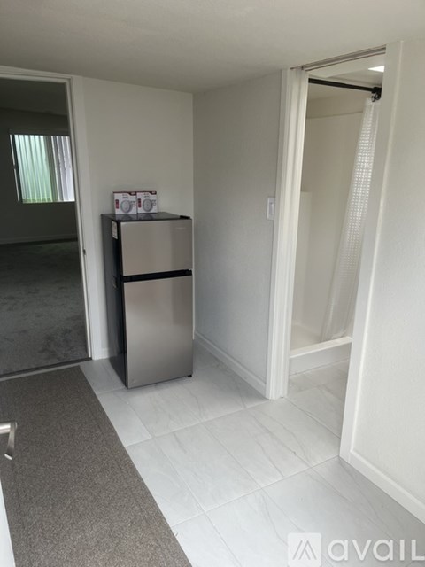 A kitchen with a fridge and a door open.