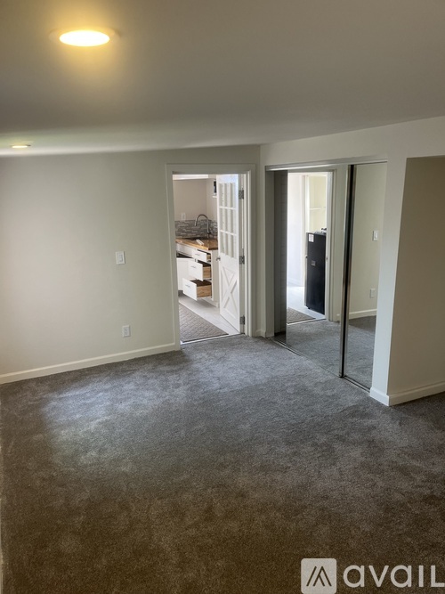 A room with a carpeted floor and a doorway leading to another room.